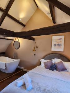 a bedroom with a large bed and a bath tub at Rose & Star Cottage in Frome