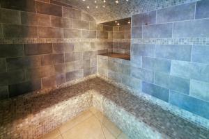 a bathroom with a shower with blue tiles at Logis Hôtel Le Rochelois in La Rochelle