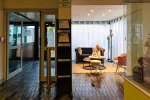 a lobby with a living room and a table and chairs at Logis Hôtel Le Rochelois in La Rochelle