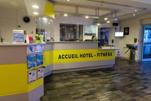 a lobby of a hotel with a yellow counter at Logis Hôtel Le Rochelois in La Rochelle