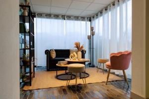 a living room with a couch and a table and chairs at Logis Hôtel Le Rochelois in La Rochelle +37 photos