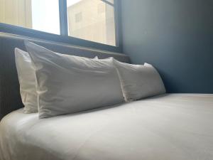 a bed with three pillows on top of it at 未艾公寓WeLove Apartment in Hsin-ying