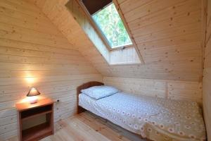 een slaapkamer met een bed in een houten hut bij Year round holiday house with a terrace near the sea Pustkowo in Pustkowo