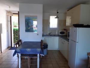 a small kitchen with a table and a refrigerator at LE LAVANDOU ST CLAIR MAZET CLIM 5 pers 500 m de mer in Le Lavandou