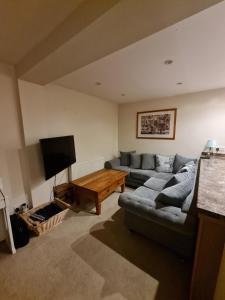 a living room with a couch and a tv at Double Room near Airport in Takeley
