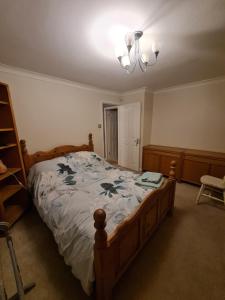 a bedroom with a bed and a chandelier at Double Room near Airport in Takeley
