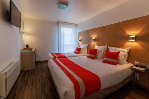 a hotel room with a large bed with red pillows at Logis Hôtel Le Rochelois in La Rochelle