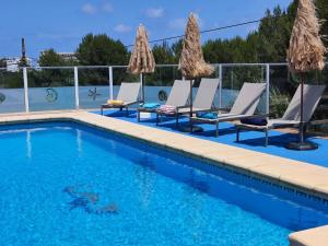 a swimming pool with chaise lounges and chairs at Villa Gota de Mar in Jávea