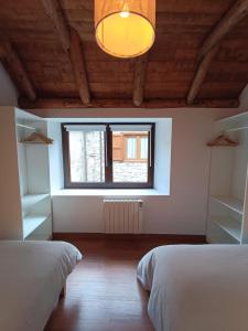une chambre avec deux lits et une fenêtre dans l'établissement Arties Centro 2 habitaciones, exclusivo familias, à Arties