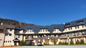 a large apartment building with a black roof at Apartment Magura in Donovaly