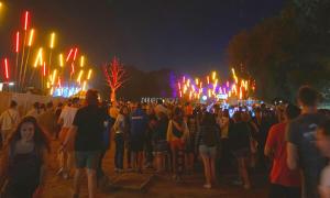 Une foule nombreuse de gens regardent un spectacle de feu la nuit dans l'établissement La Chambre d'Angèle, à Sedan