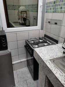a kitchen with a stove and a sink at Charmant,bien localisé et lumineux Appartement F2M/401A in Douala