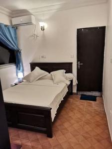 a bedroom with a large bed with a blue curtain at Charmant,bien localisé et lumineux Appartement F2M/401A in Douala