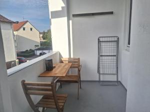 un balcone con tavolo e sedie in legno e una finestra. di Studio Apartment mit Balkon 13-2L1 a Essen