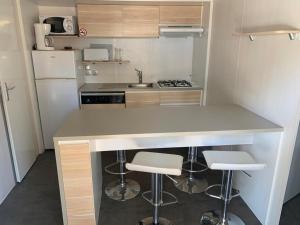 a small kitchen with a counter and stools at Camping Costa Blanca in El Campello
