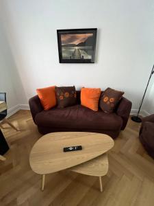 salon z brązową kanapą i stolikiem kawowym w obiekcie Esprit Forêt N0ire - appartement de luxe 3 chambres w Miluzie +19 zdjęć