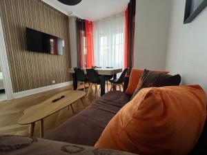 salon z kanapą i stołem z krzesłami w obiekcie Esprit Forêt N0ire - appartement de luxe 3 chambres w Miluzie
