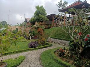 a garden with a walkway in front of a house at The Green Ponci Bedugul in Baturiti