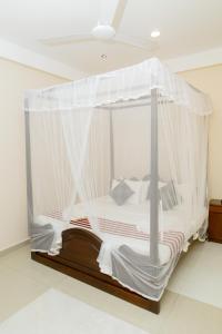 1 cama con mosquitera en una habitación en New Bay View Villa, en Weligama