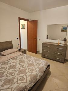 ein Schlafzimmer mit einem Bett und eine Kommode mit einem Spiegel in der Unterkunft Dolce Riposo in Manziana