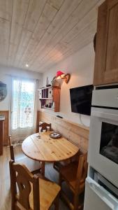 a kitchen with a wooden table and a dining room at Cocoon des sommets enneigés in La Foux +12 photos