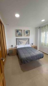 una camera con un letto e due tavoli e una finestra di Chalet Adosado Cerca Gibraltar a Alcaidesa