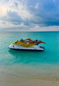 une femme qui se pose sur un hors-bord dans l'océan dans l'établissement Rasdu View Inn, à Rasdhoo