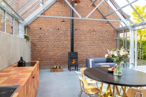 a kitchen and living room with a brick wall and a stove at stek&stoof in Sint-Pauwels