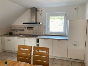 a kitchen with white cabinets and a window at Ferienwohnung Blumenau in Bad Berneck im Fichtelgebirge