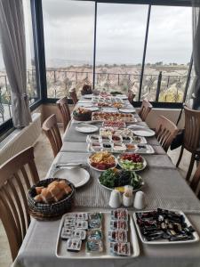 uma mesa longa com pratos de comida em Remus Romulus Cappadocia em Üçhisar