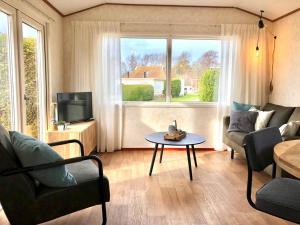 a living room with a couch and a table and a tv at Chalet De Miranda in Midsland