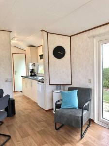 sala de estar con silla y cocina en Chalet De Miranda en Midsland