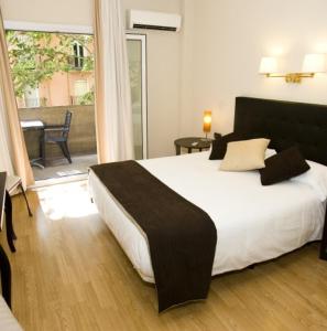 een slaapkamer met een groot bed en een balkon bij Vernisa in Xàtiva