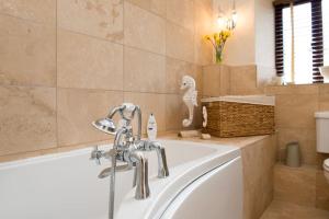 un bagno con vasca e lavandino di Unique Rural Stone dog friendly Barn Conversion a Okehampton Altre 26 foto