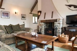 a living room with a couch and a fireplace at Unique Rural Stone dog friendly Barn Conversion in Okehampton
