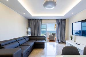 un salon avec un canapé et une télévision dans l'établissement Sea front Costa Adeje Spacious 2 bedroom apartment, à Adeje