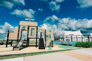 einen Spielplatz mit Rutsche neben einem Pool in der Unterkunft R'Holistay Commune Village near WEDDING CHURCHES in Nasugbu