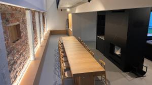 - une grande table et des chaises dans une pièce dotée d'un mur en briques dans l'établissement LedowoHouse Industrial Style kids friendly, à Lędowo