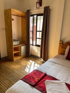 1 dormitorio con 1 cama y 1 habitación con ventana en Liberty Place en Luang Prabang