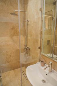 ビシュケクにあるRivieraのバスルーム(洗面台、ガラス張りのシャワー付)
