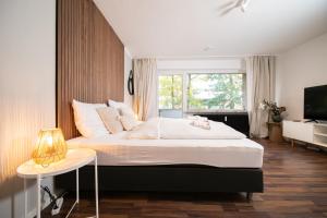 ein Schlafzimmer mit einem großen Bett und einem Fenster in der Unterkunft Favorite Stays - Suite and More - Westfeld in Neuss