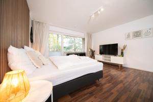 a bedroom with a large bed and a television at Favorite Stays - Suite and More - Westfeld in Neuss