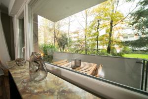 uma varanda com uma mesa e uma grande janela em Favorite Stays - Suite and More - Westfeld em Neuss