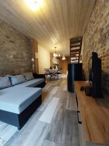 uma sala de estar com uma cama e uma parede de pedra em Gîte La Grange em Chooz