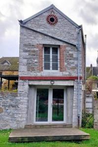 um edifício de tijolos com uma janela e uma porta em Gîte La Grange em Chooz