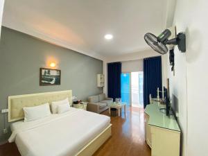 a bedroom with a white bed and a television at A25 Hotel - 35 Mạc Thị Bưởi in Ho Chi Minh City +19 photos