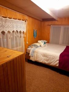 a bedroom with two beds and a dresser in it at Arrayan The Cuyen in Puerto Cisnes