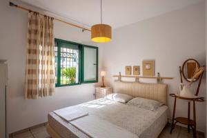 a bedroom with a bed and a window at Seaside Bungalow in Pefkochori