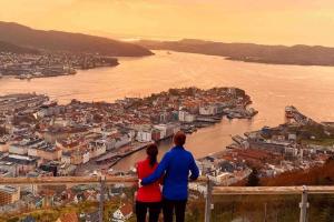 a man and woman standing on a ledge overlooking a river at Austefjorden hytte ved havet! in Forland