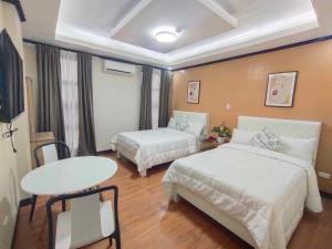 a hotel room with two beds and a table at SouthPark Hotel Naga in Concepcion